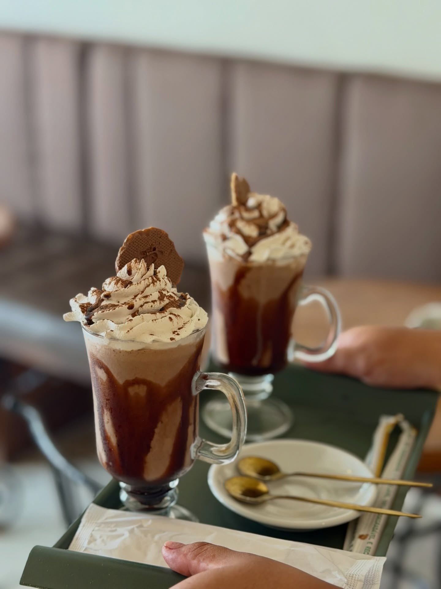 Dois copos altos de café com chocolate, chantilly e biscoito