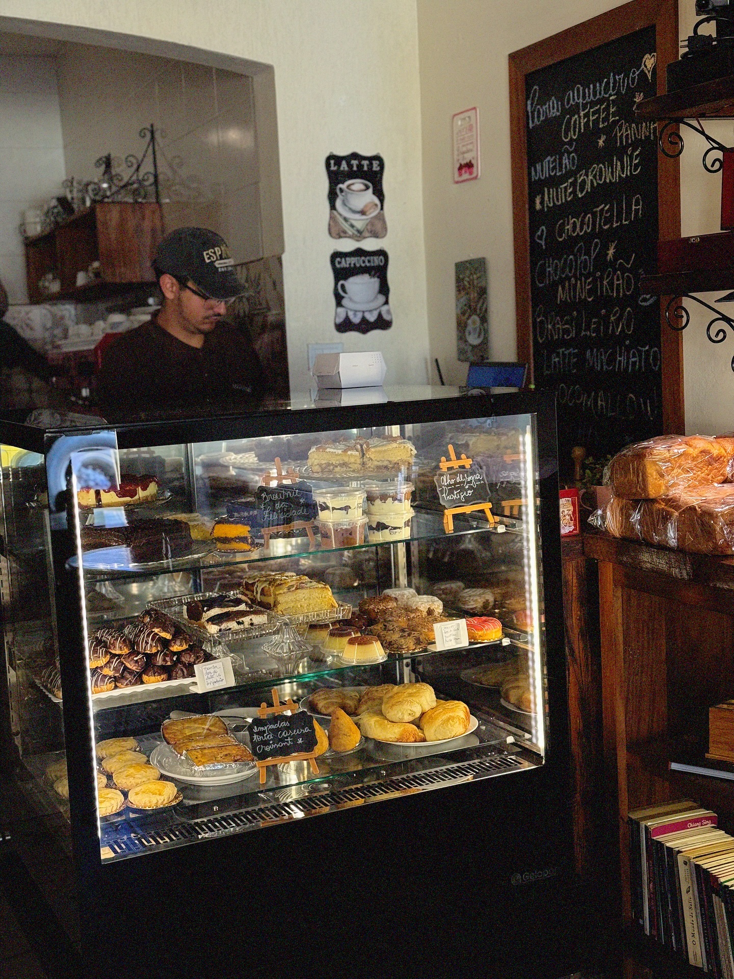 Vitrine iluminada com bolos, tortas e doces do dia